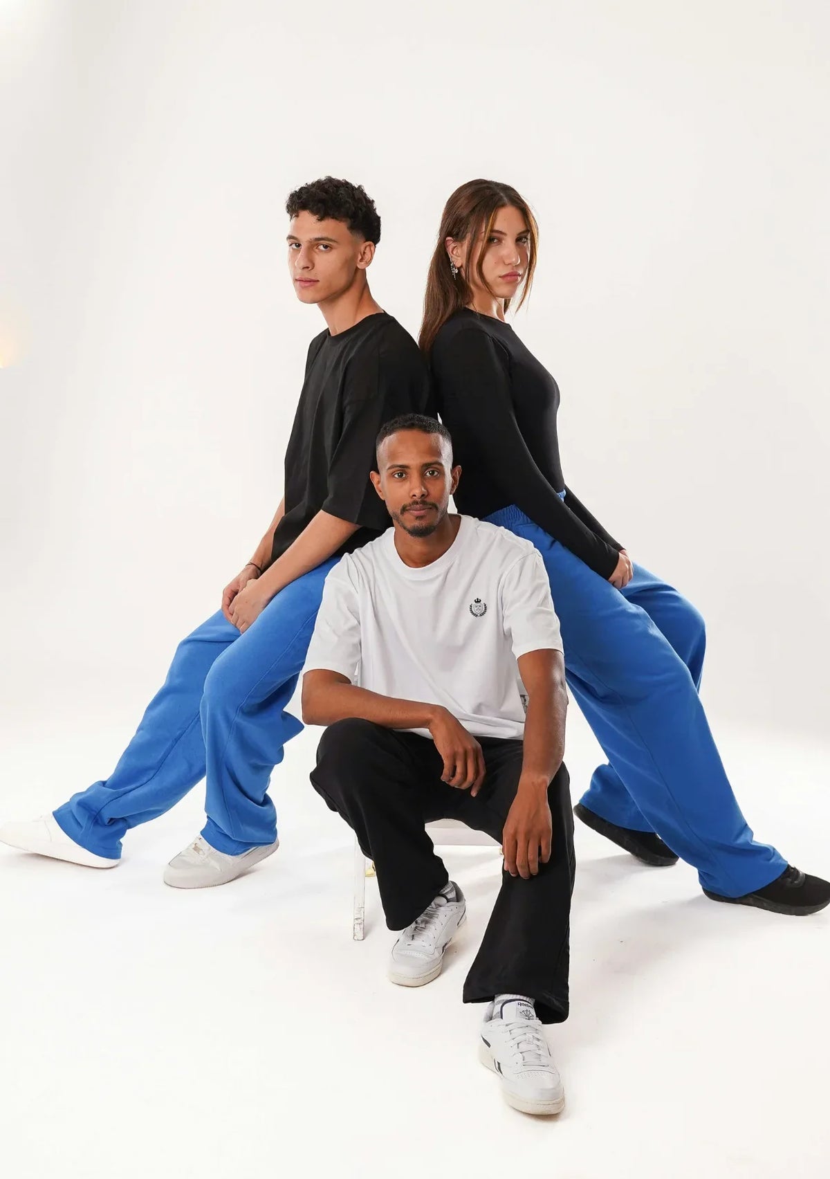 A group of diverse models pose in the latest CozyVora apparel, including comfortable t-shirts and relaxed-fit track pants in blue and black.