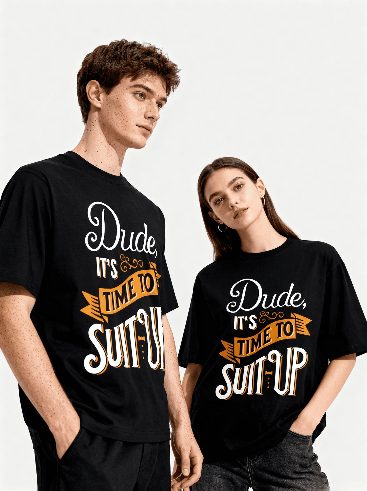 Two people wearing black t-shirts with a humorous print on a plain background.
Text is "Dude it's Time to Suit Up".