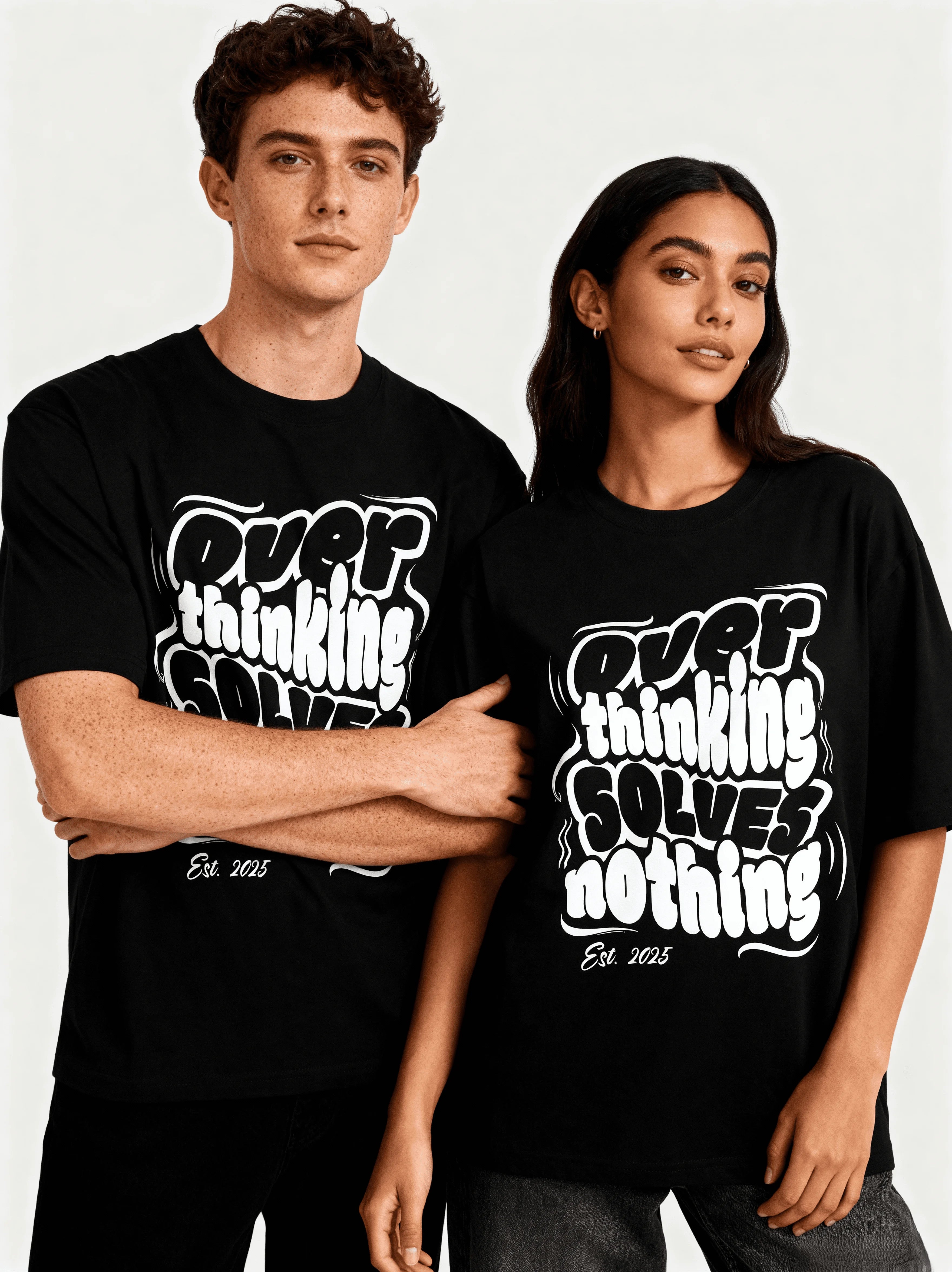 Two people wearing black t-shirts  and "Over Thinking Solves Nothing" is written on T-shirt with white text on a plain background