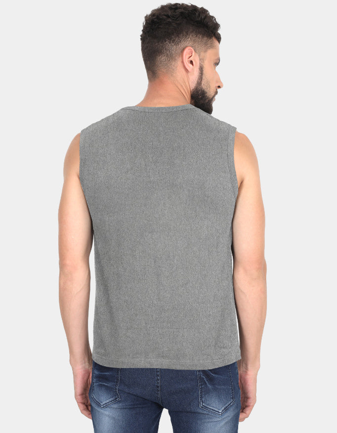 Man wearing a gray sleeveless shirt and blue jeans on a light gray background
Clyne Tee