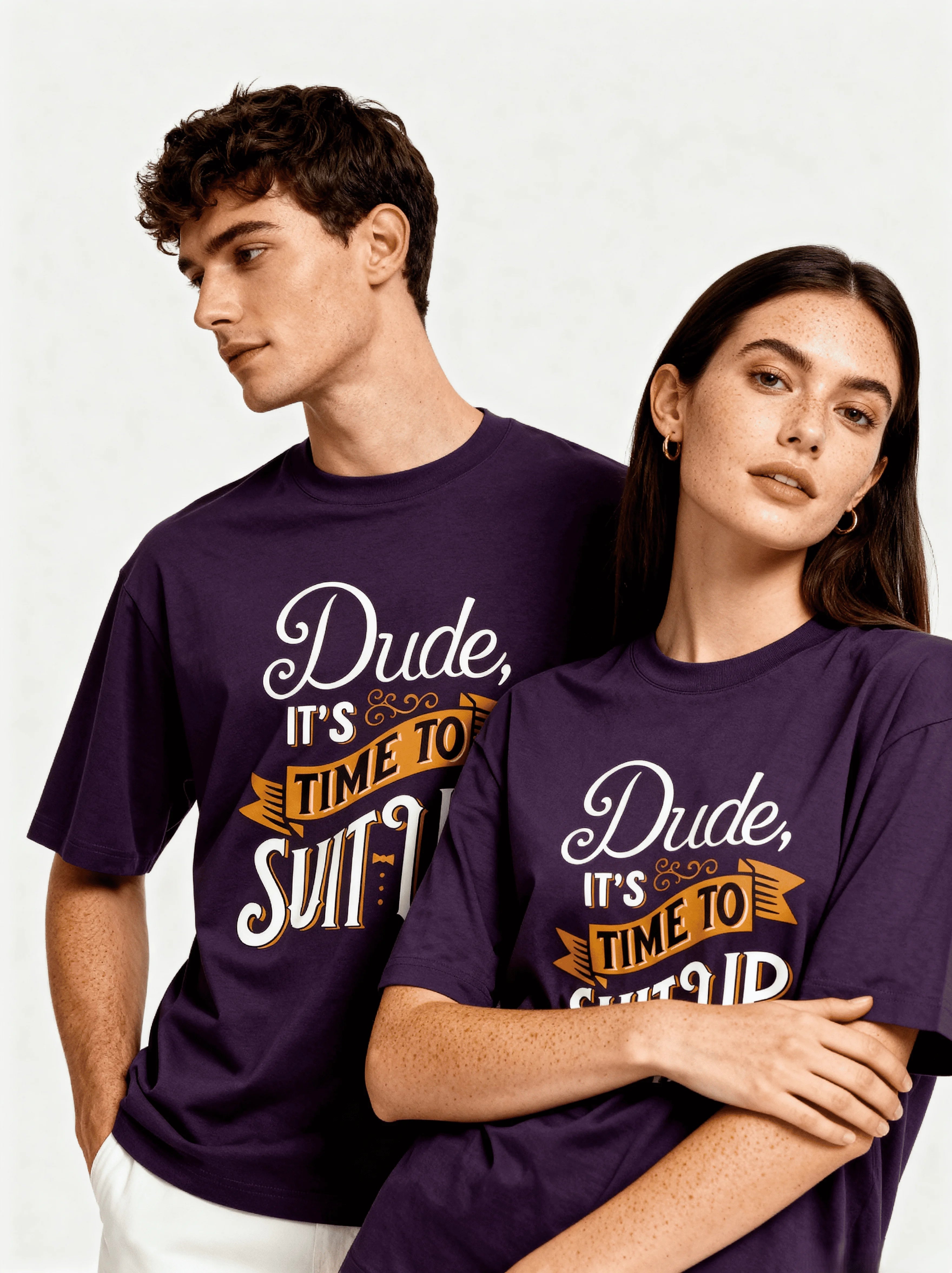 Two people wearing purple CozyVora t-shirts with humorous text design on a plain background...text is "Dude it's Time to Suit Up".