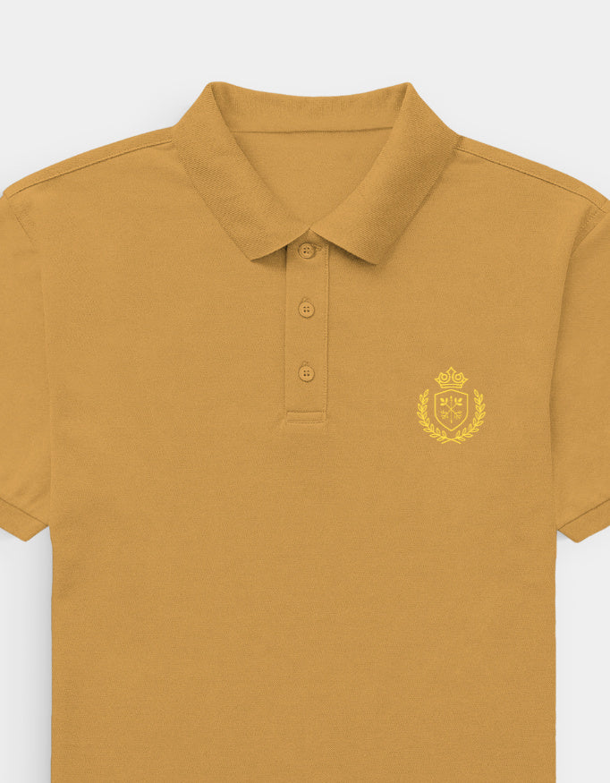 Mustard yellow polo shirt with a crest on a light gray background
Ravlen Polo