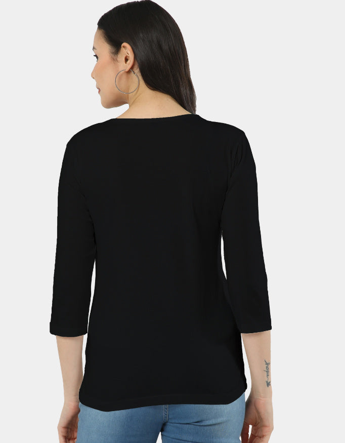 Woman wearing a black top with a plain background
The Linea Tee