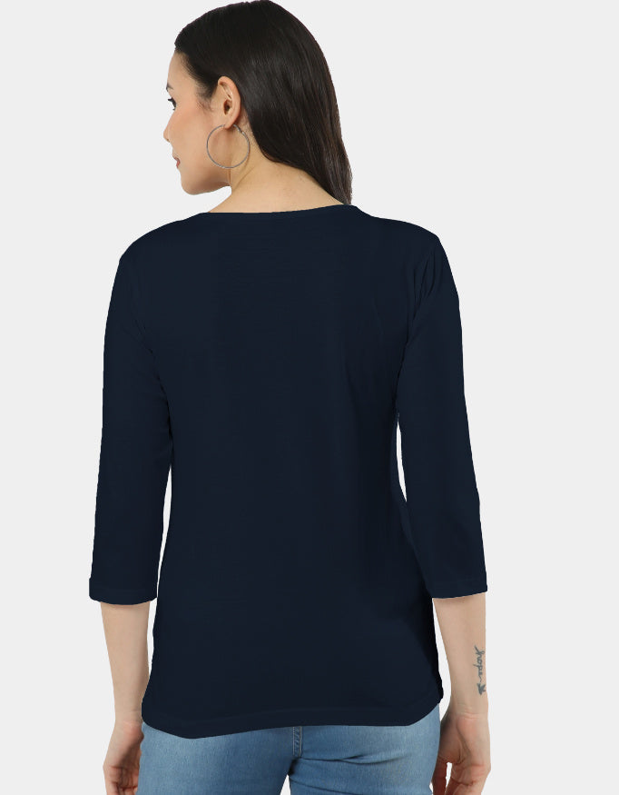 Woman wearing a navy blue top with three-quarter sleeves on a white background