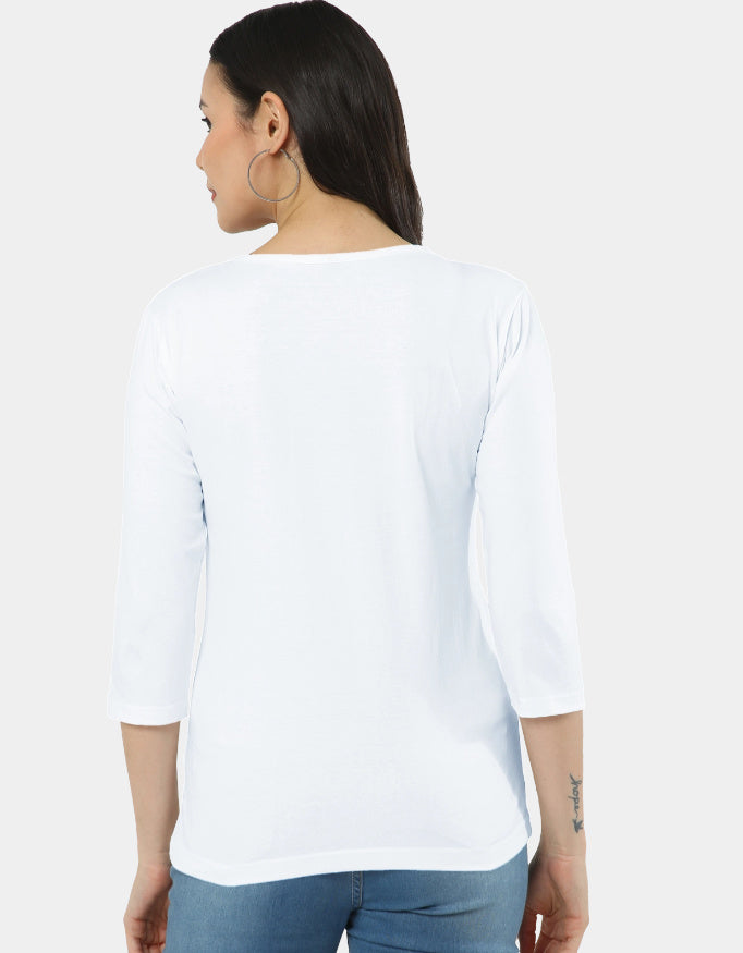 Woman wearing a white top and blue jeans on a plain background
The Linea Tee