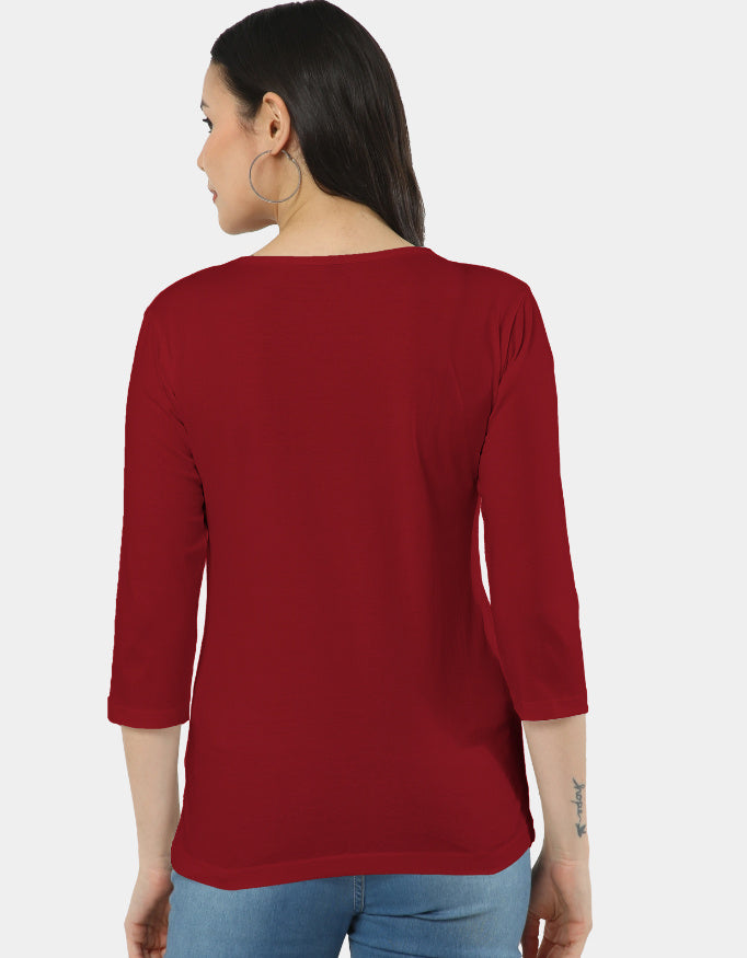 Woman wearing a red top with a plain background
The Linea Tee